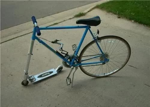 A humorous photo of a bicycle with its front wheel replaced by a kick scooter, illustrating a hacky improvised fix.